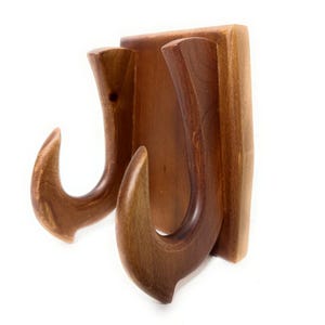 May include: A wall-mounted wooden hook rack featuring two curved, upward-facing prongs attached to a rectangular wooden base. The object is crafted from polished brown wood with visible natural grain patterns and a smooth, rounded finish throughout.