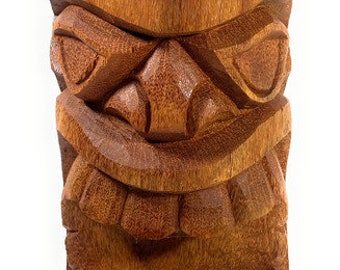 May include: A carved wooden tiki statue with a fierce expression. The statue has a detailed face with a wide mouth, large eyes, and a prominent nose. The statue is made of a dark brown wood and has a smooth, polished finish.