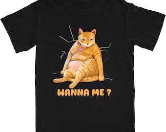 Könnte beinhalten: Schwarzes T-Shirt mit einer Cartoon-Illustration einer orangefarbenen Tabby-Katze und dem Text "WANNA ME?". Die Katze trägt ein rosa Halsband und sitzt. Weiße Linien sind im Hintergrund.