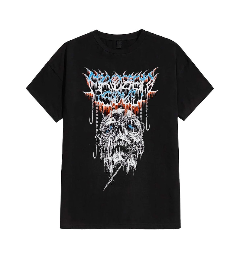 May include: Black t-shirt with a graphic design. The design features a skull with blue eyes, suspended by chains, and the text "MORTAL REBELLION" in blue and orange. The shirt is made of a soft material.