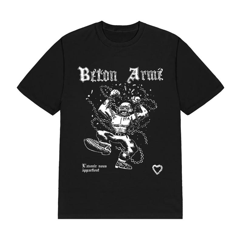 Op de afbeelding: Een zwart t-shirt met korte mouwen en een witte grafische print van een gespierd figuur dat kettingen doorbreekt. De tekst "B&eacute;ton Arm&eacute;" staat bovenaan, met "L'avenir nous appartient" en een kleine hartvormige kettingschakel onderaan.
