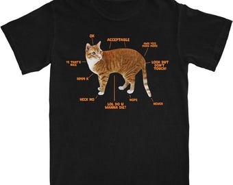Pode incluir: Camiseta preta com um gato de desenho animado em laranja e branco. O gato tem etiquetas como "OK", "Acceptable" e "Look but don't touch!". Um item humorístico.