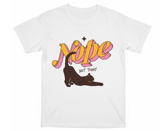 May include: White t-shirt featuring a brown cat stretching. The word "Nope" is in yellow and pink bubble letters above the cat, with the words "NOT TODAY" below. A black star is above the cat.