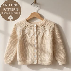 Könnte beinhalten: Eine cremefarbene Langarm-Strickjacke mit texturiertem Perlmuster am Körper und einer dekorativen Passe mit Blattmuster. Das Kleidungsstück hat einen Rundhalsausschnitt, gerippte Bündchen und eine Knopfleiste mit sieben weißen Knöpfen. Text: KNITTING PATTERN digital download.