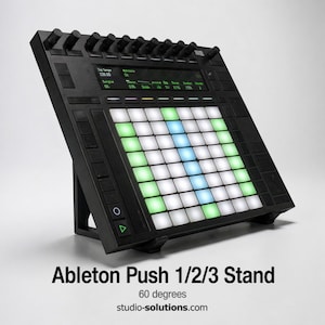 May include: Black Ableton Push 1/2/3 stand with a 60-degree angle. The stand features a grid of illuminated white, green, and blue pads, along with a display screen and control knobs. The text "Ableton Push 1/2/3 Stand" is visible.