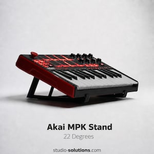 Può includere: Un supporto Akai MPK rosso e nero con tastiera e manopole di controllo. Il supporto è angolato a 22 gradi e ha una struttura di supporto nera. I tasti della tastiera sono bianchi e neri e il pannello superiore ha dei pad illuminati di rosso.