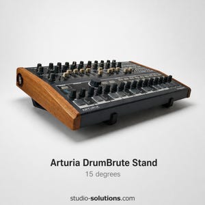 Op de afbeelding: Arturia DrumBrute Stand, een zwart en bruin elektronisch muziekproductie-apparaat. De standaard staat onder een hoek van 15 graden. Het apparaat heeft talrijke knoppen en draaiknoppen, met het Arturia-logo zichtbaar. De standaard heeft houten zijpanelen.