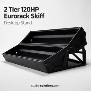 May include: A black 2-tier Eurorack skiff desktop stand. The stand has a rectangular shape with two levels and is designed to hold modular synthesizer modules. The text "2 Tier 120HP Eurorack Skiff Desktop Stand" is visible. The website studio-solutions.com is also visible.