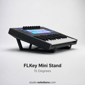 May include: Black FLKey Mini Stand, angled at 15 degrees, with a built-in keyboard and control panel. The stand features a sleek design with a series of knobs and a display panel with blue and purple lights. The product name and website are visible.