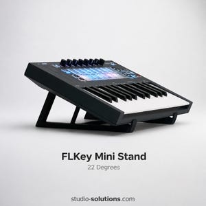 May include: Black FLKey Mini keyboard on a black stand, angled at 22 degrees. The keyboard has white and black keys, with illuminated controls. The stand is designed to elevate the keyboard for optimal use.