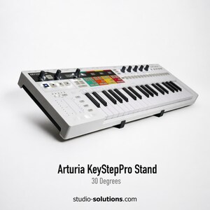 May include: A white Arturia KeyStepPro stand with black keys and control knobs. The stand has a colorful control panel and is angled at 30 degrees. The text "Arturia KeyStepPro Stand" is visible.