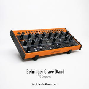 May include: An orange and black Behringer Crave synthesizer stand with numerous knobs and buttons. The stand is angled at 30 degrees and has the text "Behringer Crave Stand" and "30 Degrees" printed on the front.