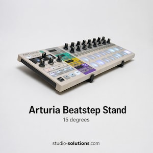 Könnte beinhalten: Ein beigefarbener Arturia Beatstep-Ständer, der um 15 Grad abgewinkelt ist. Der Ständer verfügt über eine Vielzahl von Knöpfen und Pads in verschiedenen Farben. Der Text "Arturia Beatstep Stand" ist darunter angezeigt.