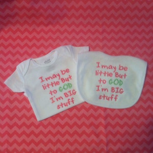 May include: White baby onesie and bib with pink and green embroidery. The text reads "I may be little but to God I'm big stuff".
