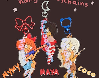 Può includere: Tre portachiavi in acrilico con i personaggi dei cartoni animati Mymy, Maya e Coco. Mymy ha i capelli arancioni e tiene in mano un fucile, Maya ha i capelli scuri e calze a righe, e Coco ha lunghi capelli bianchi. Ogni portachiavi ha una chiusura.