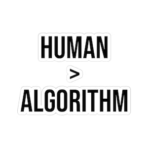 Op de afbeelding: Een witte sticker met de tekst "HUMAN > ALGORITHM" in een vetgedrukte, zwarte lettertype. Het woord "HUMAN" staat boven "ALGORITHM", met een groter dan-teken ertussen.