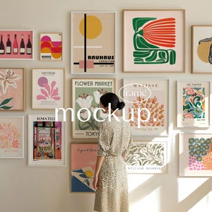 May include: A wall display of framed art prints featuring various abstract and botanical designs. The prints include text such as "BAUHAUS EXHIBITION" and "FLOWER MARKET TOKY". The color palette includes pinks, greens, yellows, and blues.