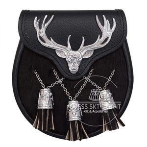 May include: A black leather sporran featuring a silver-toned metal stag head emblem on the flap. Three silver chains hang from the front, each attached to a silver cap with a stag motif and black leather tassels. The text DRESS SKT OUTFIT Kilt & Accessories is visible.