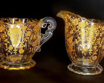 Juego de lechera y azucarero de cristal grabado Cambridge Rose Point con detalles dorados.