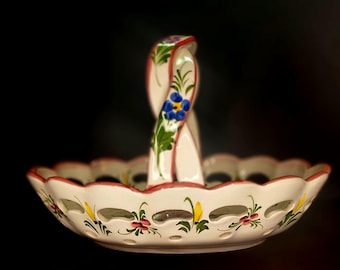 Cesta de frutas de cerámica portuguesa pintada a mano con motivo floral y asa trenzada.