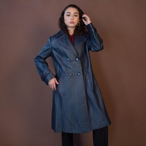 May include: A long, blue leather trench coat with a double-breasted closure and a belt.