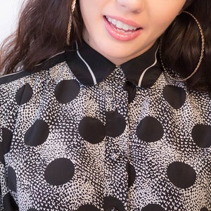 Peut inclure: Une chemise &agrave; pois noirs et blancs avec un col blanc et une fermeture &agrave; boutons.
