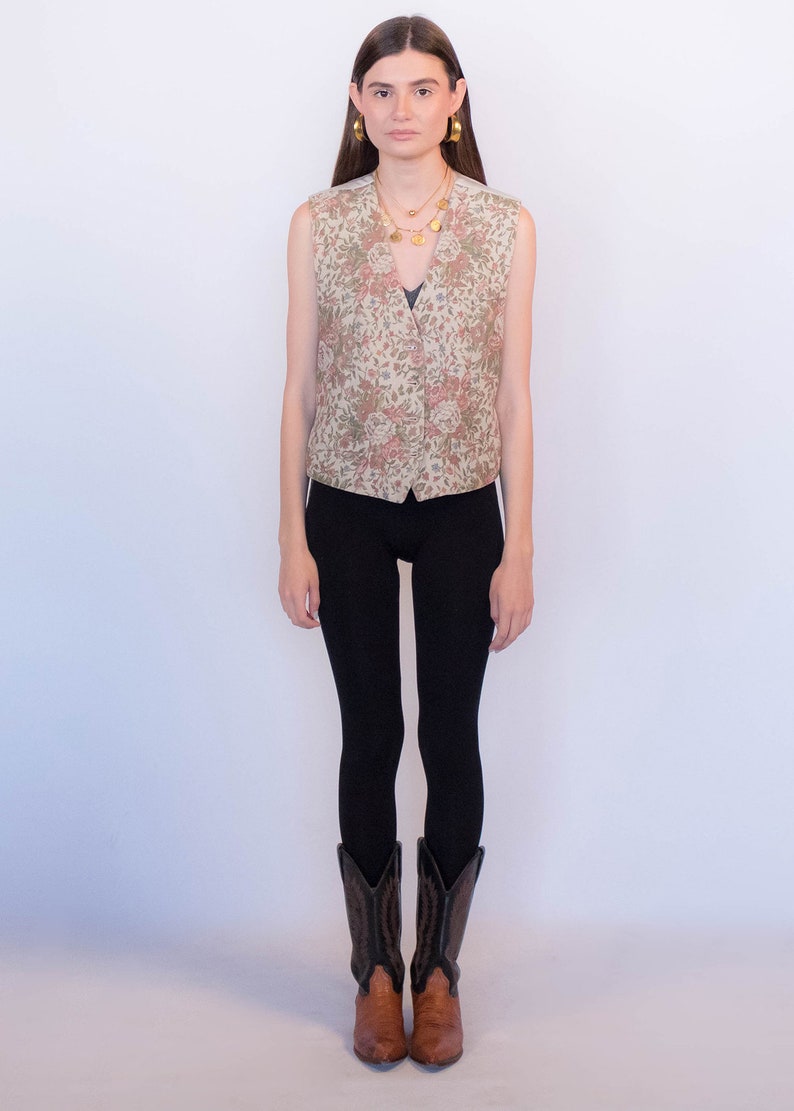 May include: A woman wearing a floral patterned vest, black leggings, and brown cowboy boots.
