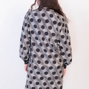 Peut inclure: Une robe &agrave; pois noirs et blancs &agrave; manches longues et col.