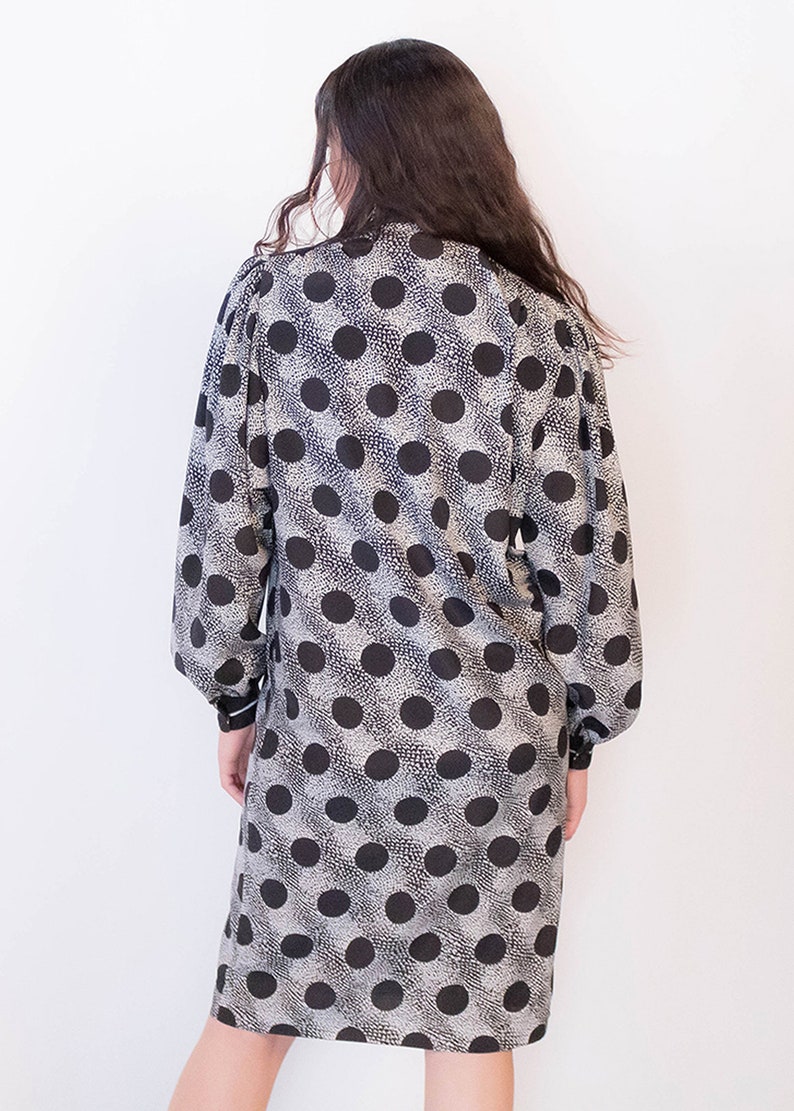 Peut inclure: Une robe &agrave; pois noirs et blancs &agrave; manches longues et col.