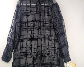 May include: A sheer black button-down shirt with a grid pattern. The long-sleeved blouse has a collared neckline and buttons down the front. A tag hangs from the bottom of the shirt. The shirt is hanging on a white hanger.