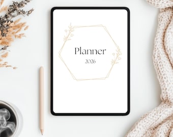 Könnte beinhalten: Ein digitaler Planer für 2026 mit dem Wort "Planner" in einem goldenen geometrischen Rahmen. Eine Tasse Kaffee, ein Bleistift und Trockenblumen sind auf einer weißen Oberfläche angeordnet, mit einer beigefarbenen Strickdecke im Hintergrund.
