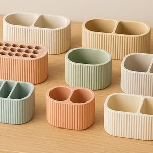 以下が含まれることがあります： パステルカラーのリブ付きデスクオーガナイザーのコレクション。オーガナイザーには、シングル、ダブル、トリプルコンパートメントのコンテナ、および複数の穴のある円筒形のホルダーが含まれます。色はピーチ、セージグリーン、クリームです。