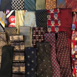 Könnte beinhalten: Eine Sammlung von Krawatten mit verschiedenen Mustern, darunter Punkte, Streifen, geometrische Formen, florale Motive und ein Billardkugel-Druck. Die Krawatten sind in einer Vielzahl von Farben wie Rot, Blau, Schwarz, Braun und Grün dargestellt.