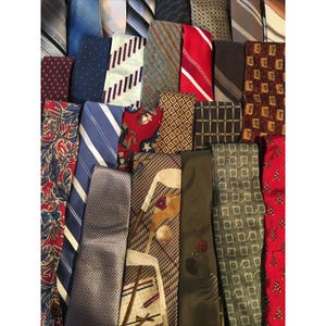 Peut inclure: Une collection de cravates présentant divers motifs et couleurs, notamment rouge, bleu, vert, marron et gris. Les cravates affichent des designs variés tels que des rayures, des formes géométriques, des motifs de golf et des imprimés floraux.
