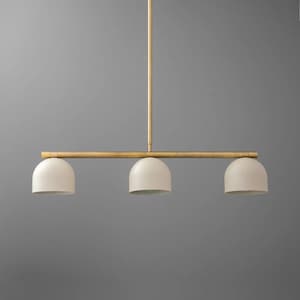 Könnte beinhalten: Moderne Pendelleuchte mit drei Lichtern und goldfarbenem Finish. Sie verfügt über drei cremefarbene, kuppelförmige Schirme, die an einer horizontalen Stange befestigt sind. Geeignet für die Deckenbeleuchtung, mit minimalistischer Ästhetik.