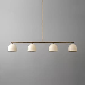 Puede incluir: Una lámpara colgante lineal que presenta una varilla de metal larga y delgada en tono bronce oscuro, suspendida de un solo vástago vertical. Cuatro pantallas en forma de cúpula de color crema mate están espaciadas a lo largo de la barra.