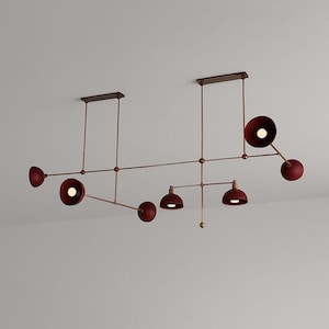 May include: A contemporary ceiling light fitting with a linear design. It features several maroon-coloured, dome-shaped lights attached to a network of bronze-coloured rods and supports. The fitting is designed to be mounted on a ceiling.