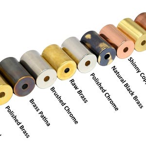 May include: A collection of cylindrical metal objects in various finishes, including matte black, copper patina, and brushed brass. The image displays a range of colors and textures, with labels identifying each finish. These are likely decorative hardware or components.
