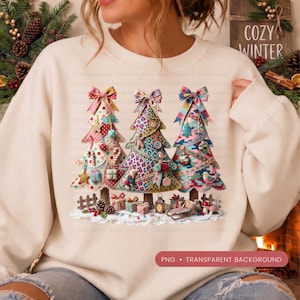 May include: A cream-colored crewneck sweatshirt featuring a graphic of three stylized Christmas trees. The trees are decorated with colorful patterns, bows, and ornaments. Beneath the trees are small gift boxes, a lantern, and a sled.