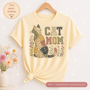 Puede incluir: Una camiseta amarilla clara con un diseño de gato patchwork y las palabras "CAT MOM". El gato está compuesto por varios patrones de tela. La camiseta también tiene el texto "Tiny paws, endless love."