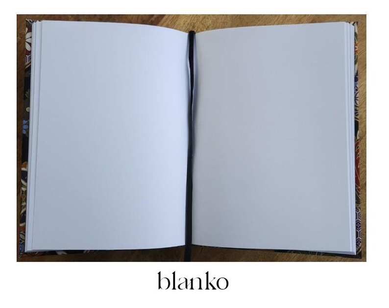 May include: Open blank notebook with a black bookmark. The notebook has a patterned cover with floral and geometric designs in shades of brown, blue, and red. The word "blanko" is printed at the bottom.