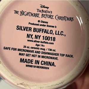 May include: A pink ceramic mug with text from Tim Burton's "The Nightmare Before Christmas." The mug is 25 oz. and safe for microwave and dishwasher use. Made in China.