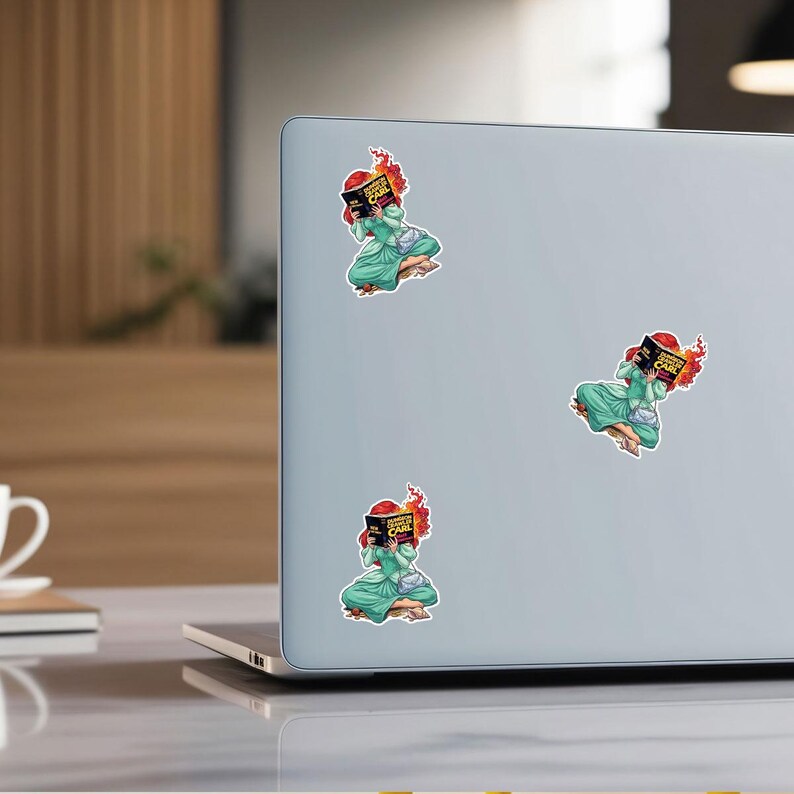 a laptop with three stickers on its back cover, each depicting a cartoon character.