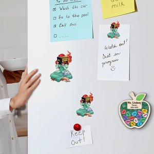 a whiteboard with various notes, stickers, and magnets attached to it. There is a person's hand visible on the left side of the image. The notes on the whiteboard include a list of tasks such as "To do: wash the car", "Go to the pool", and "Call Ann". There is also a note that says "Watch out! Diet in progress". Additionally, there are two magnets on the whiteboard, one of which is shaped like an apple with a note that says "Mr. Lindsay", and another one that has a note that says "Keep Out!".