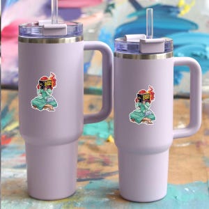 Two purple tumblers with stickers on them, placed on a colorful background.