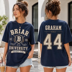 A woman wearing a navy blue t-shirt with the text "BRIAR UNIVERSITY HOCKEY CLUB" printed on it, along with the number "44".