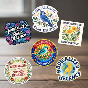 May include: A collection of colorful stickers with the phrase "Radicalized by Basic Decency" and "Radicalized by Common Decency." Designs include floral arrangements, birds, and decorative borders. The stickers are on a wooden surface.