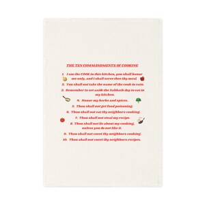 Könnte beinhalten: Cremefarbenes Küchentuch mit dem Text "THE TEN COMMANDMENTS OF COOKING" in Schwarz, gefolgt von zehn humorvollen Geboten in Rot. Enthält Illustrationen von Zwiebel, Apfel und anderen Kochsymbolen.