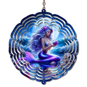 May include: A circular metal wind spinner featuring a vibrant illustration of a mermaid with long flowing purple hair, a purple tail, and a pink starfish in her hair. She is holding a seashell against a backdrop of a full moon and ocean waves.