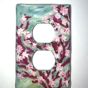 Ocean theme hand-painted on a vertical outlet wall plate cover with pink blooming coral and light grey color fish set against a blended light green color background. Artwork is protected with a resin glaze to ensure durability and give a glass like finish. Signed by Artist TDavis. Made to order with a variety of wall plate sizes available. Allow 10-14 days studio time